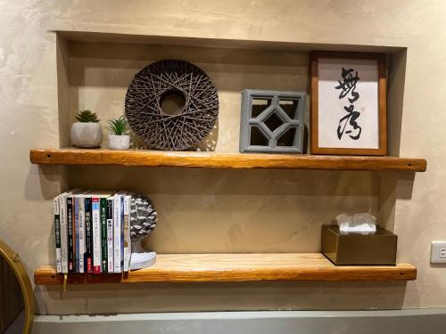 a wooden shelf with books and other items on it at 唯識禪居-訂房後需聯繫轉帳 in Tainan