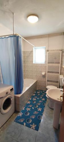 a bathroom with a tub and a toilet and a sink at Apartmani Kevric in Novi Vinodolski