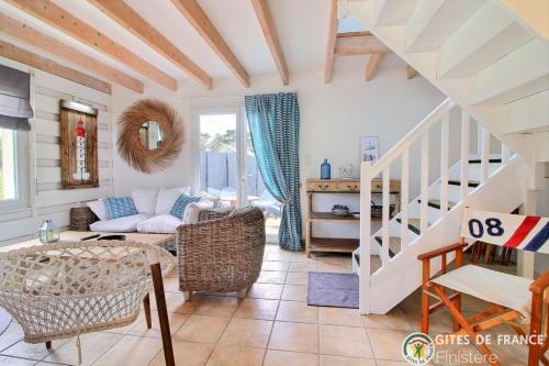 a living room with a staircase and a couch at Les gites du bord de mer in Plouarzel