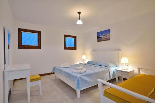 a bedroom with a bed and a desk and two tables at Dreamy Villa near Beach with Backyard in Bozcaada in Canakkale