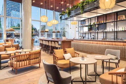 um restaurante com mesas e cadeiras e um bar em INNSiDE by Meliá Amsterdam em Amesterdão