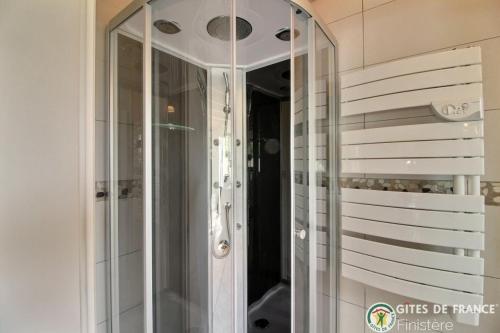 La salle de bains est pourvue d'une douche en verre avec un miroir. dans l'établissement Les gites du bord de mer, à Plouarzel