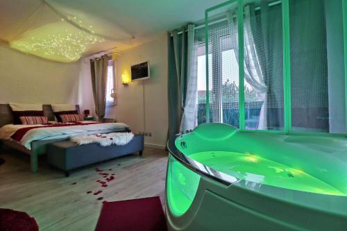 1 dormitorio con 1 cama y baño con bañera. en Nuit Romantique avec Jacuzzi à 15 min de Toulouse en Blagnac