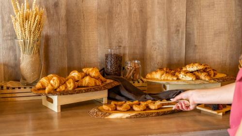 een persoon die een mes vasthoudt voor meerdere borden brood bij Apartahotel Suites Vila Birdie in Navata