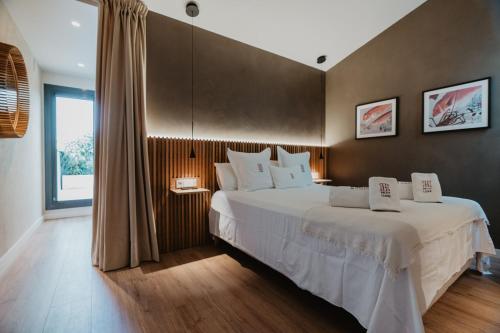 a bedroom with a large bed and a large window at Petit Luxe Volta ÀTIC in Terrassa