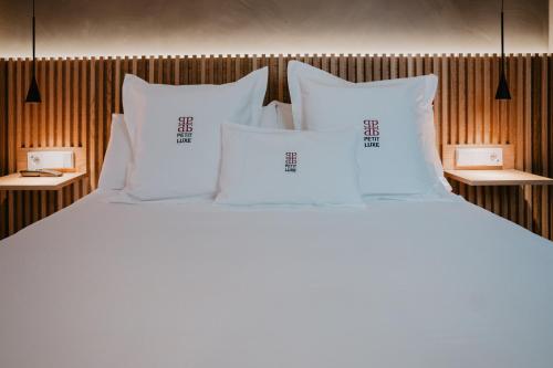 a large white bed with white pillows on it at Petit Luxe Volta ÀTIC in Terrassa