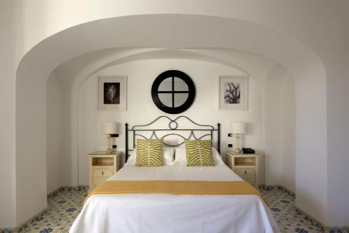 a bedroom with a bed with yellow and white pillows at Hotel Canasta in Capri