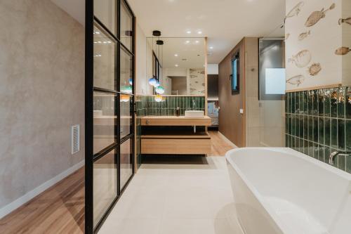 a bathroom with a tub and a sink at Petit Luxe Volta ÀTIC in Terrassa