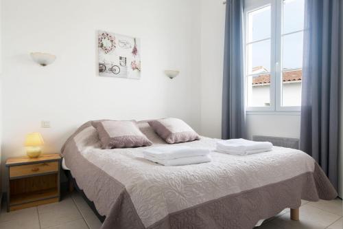 CIVELLE Appartement proche Centre et Plages في لا كوردي سور مير: غرفة نوم عليها سرير وفوط