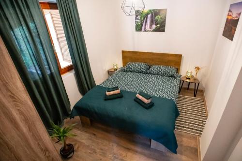 ein kleines Schlafzimmer mit einem Bett mit einer grünen Decke in der Unterkunft Holiday home Tilia in Slatinski Drenovac