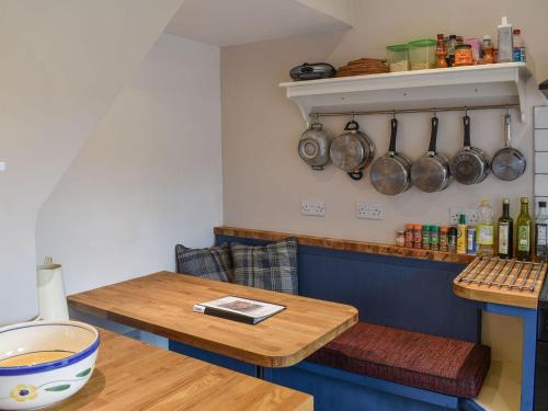 una mesa en una cocina con ollas y sartenes en la pared en Vine Cottage, en Crich