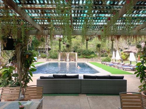 a swimming pool with a couch and a pergola at Let's Hyde Pattaya Resort & Villas - Pool Cabanas in Pattaya North