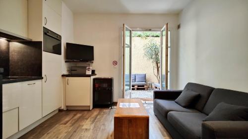 a living room with a couch and a table at Appartement maison Jeanne by Booking Guys in Nice