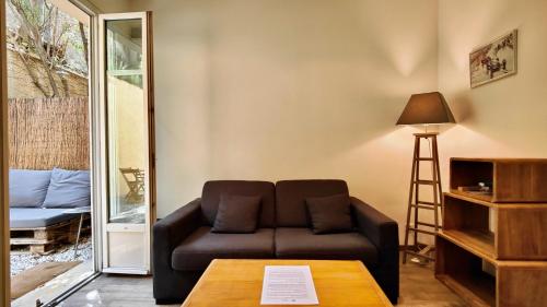 a living room with a couch and a table at Appartement maison Jeanne by Booking Guys in Nice