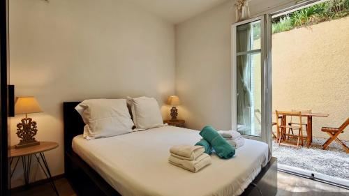 1 dormitorio con 1 cama con toallas en Appartement maison Jeanne by Booking Guys en Niza