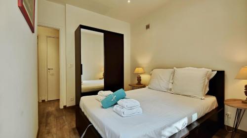 a bedroom with a bed with towels on it at Appartement maison Jeanne by Booking Guys in Nice