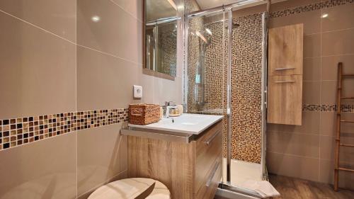 uma casa de banho com um lavatório, um chuveiro e um WC. em Appartement maison Jeanne by Booking Guys em Nice
