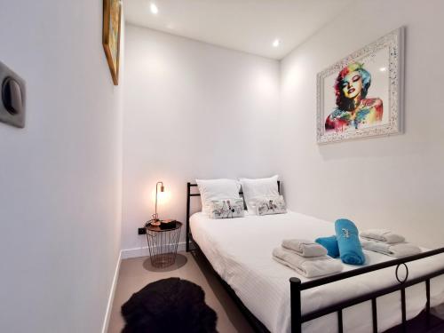 a bedroom with a bed and a picture on the wall at Le PETIT BALCON by Booking Guys in Nice