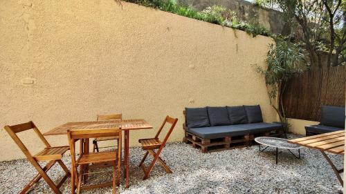 a patio with a table and chairs and a couch at Appartement maison Jeanne by Booking Guys in Nice