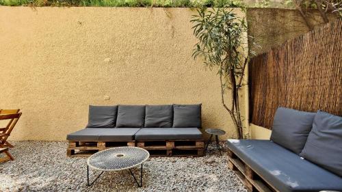 a couch and a table next to a wall at Appartement maison Jeanne by Booking Guys in Nice