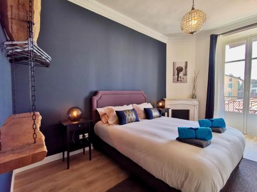 een slaapkamer met een groot bed met blauwe muren bij Le LORRAINE in Nice