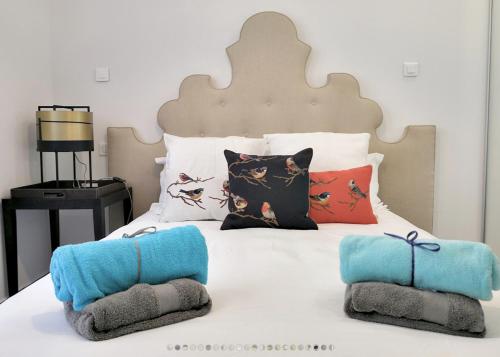 un lit blanc avec des oreillers et des serviettes dessus dans l'établissement Appartement 'EMILIA', à Nice