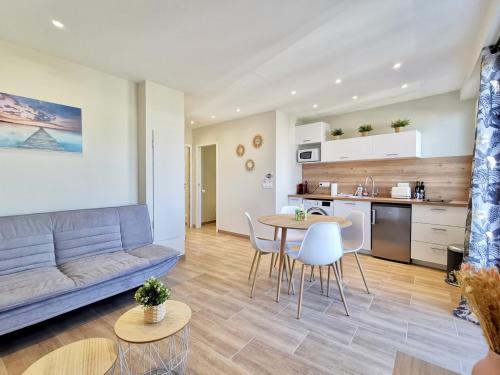 un salon avec un canapé, une table et des chaises dans l'établissement Appartement Bash11 by Booking Guys, à Nice