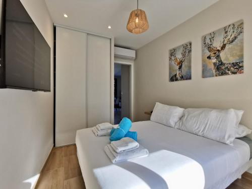 - une chambre avec un lit blanc, des serviettes et une télévision dans l'établissement Appartement Bash11 by Booking Guys, à Nice