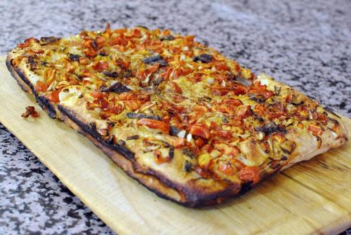 a pizza sitting on top of a wooden cutting board at La Vecchia Quercia in Selci