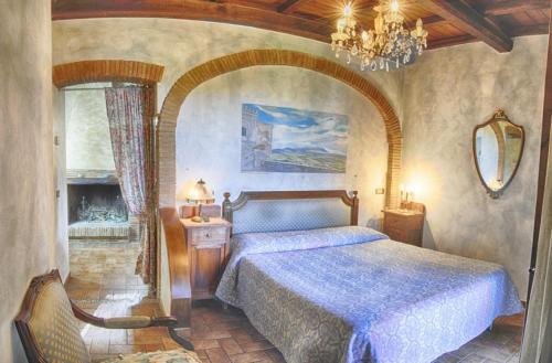 a bedroom with a bed and a chandelier at La Vecchia Quercia in Selci