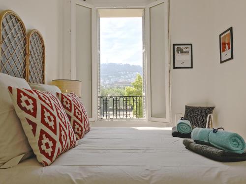 a bed in a room with a large window at Le SCALIERO in Nice