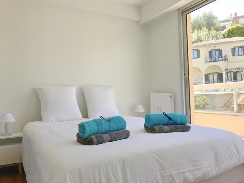 a bedroom with a white bed with two pillows on it at Appartement 'Eucalyptus' in Nice