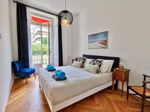 une chambre avec un lit et une chaise bleue dans l'établissement Le MASSENET by Booking Guys, à Nice