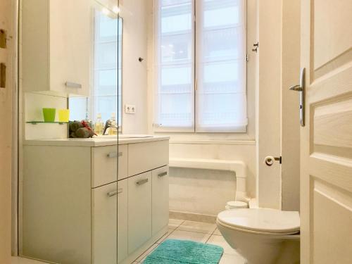 une salle de bain avec toilettes, lavabo et fenêtre dans l'établissement Le 'PHILIBERT', à Nice