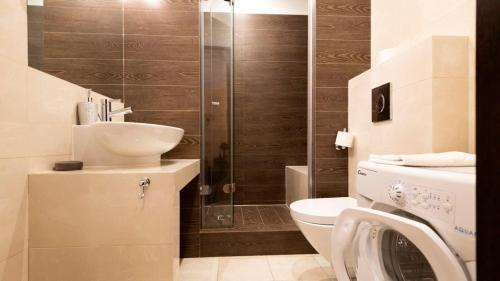e bagno con servizi igienici, lavandino e doccia. di Apartament Przytulny ZETA-PARK a Ustroń