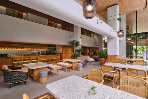 a restaurant with tables and chairs and a bar at ARTOTEL Casa Kuningan in Jakarta