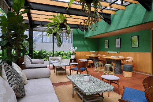 a living room with furniture and tables and plants at ARTOTEL Casa Kuningan in Jakarta