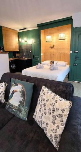 un salon avec un lit et un canapé dans l'établissement L'air du large deux étoiles, à Dieppe