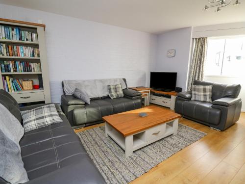 a living room with two couches and a coffee table at 1 St Marys Court in Tenby