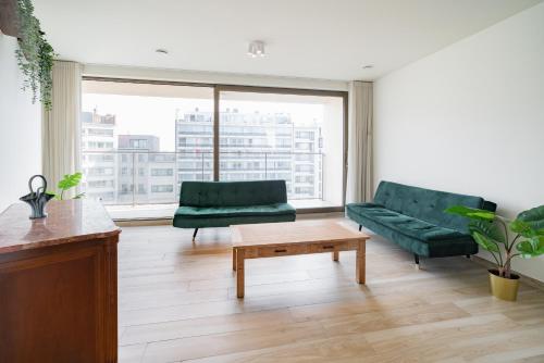 a living room with a green couch and a coffee table at Opera Square Apartments in the Center of Antwerp in Antwerp