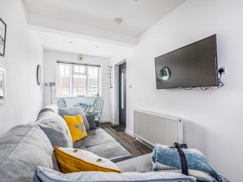 a living room with a couch and a flat screen tv at Pass the Keys Charming Annexe w Garden Parking Pass The Keys in Chichester