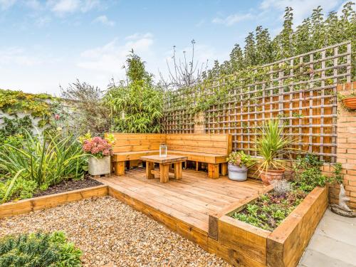 a garden with a wooden bench and a table at Pass the Keys Charming Annexe w Garden Parking Pass The Keys in Chichester