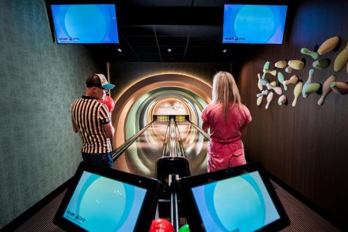 a man and a woman standing in a bowling alley at Van der Valk Hotel Gilze-Tilburg in Tilburg