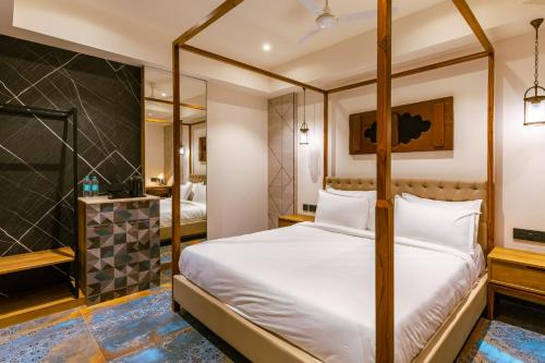 a bedroom with a four poster bed and a bathroom at Avana- A Boutique Hotel in Hyderabad