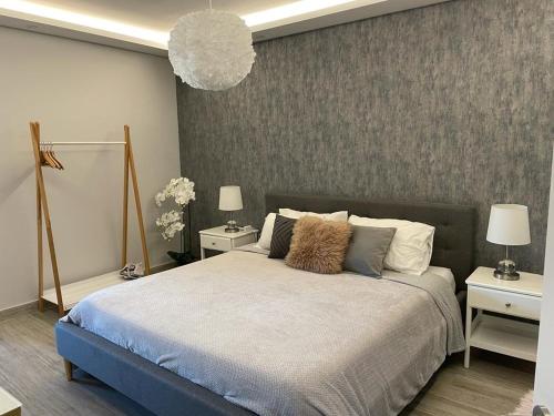 a bedroom with a large bed with two tables and two lamps at Ana Seafront Haven Apartment in Il-Gżira