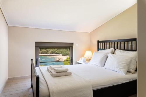 a bedroom with a large bed with towels on it at Villa Idyle - Luxury Beachfront Residence in Tragána
