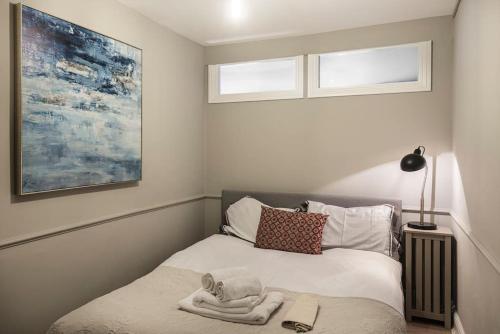 a bedroom with a bed with a towel on it at Nelson Crescent East : Modern one bedroom basement apartment in central location in Kent