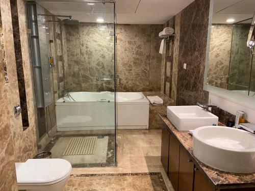a bathroom with a shower and a sink and a toilet at Fortune Select Exotica, Navi Mumbai - Member ITC's Hotel Group in Navi Mumbai