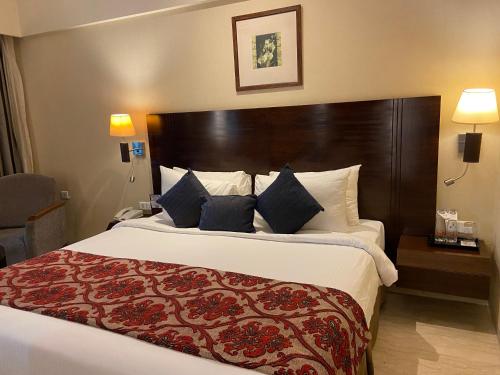a bedroom with a large bed with a large wooden headboard at Fortune Select Exotica, Navi Mumbai - Member ITC's Hotel Group in Navi Mumbai