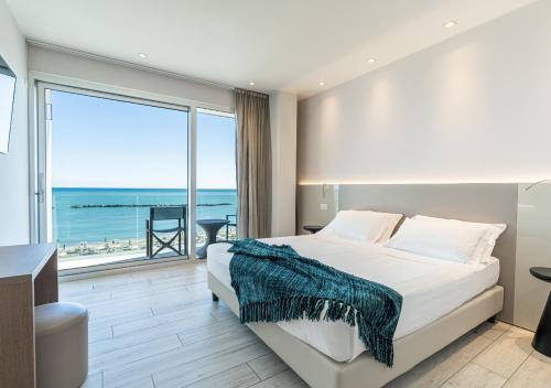 a bedroom with a bed and a view of the ocean at Hotel Savini in Bellaria-Igea Marina